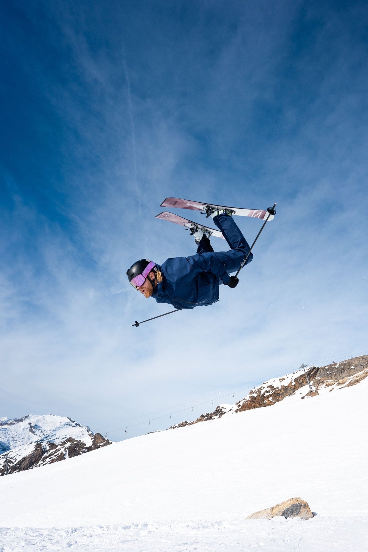 Bene Aste maakt een backflip op ski's in de bergen